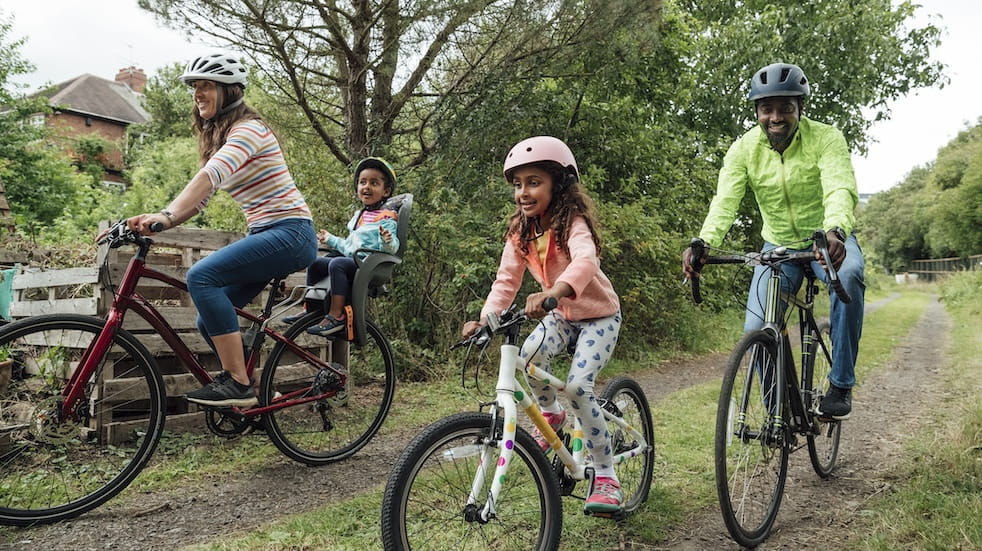 Family of four riding bikes on public footpath 